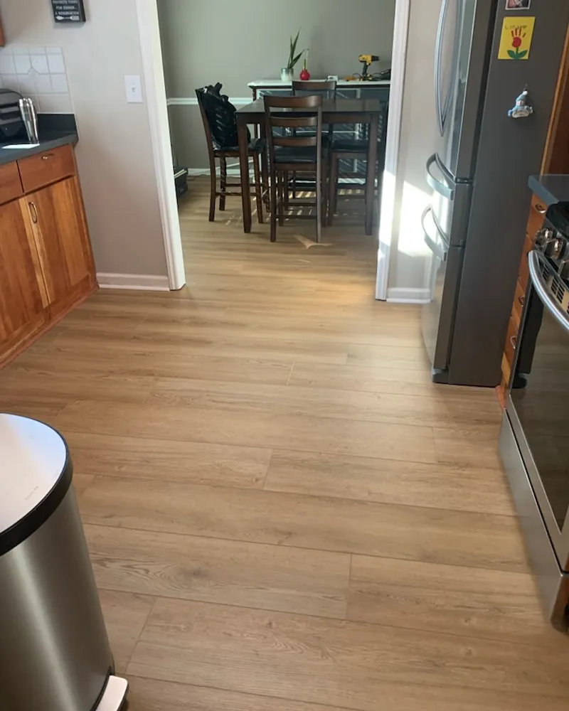 Same kitchen and dining room with continuous new flooring
